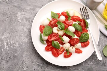 Tasty salad Caprese served on grey table, top view. Space for text
