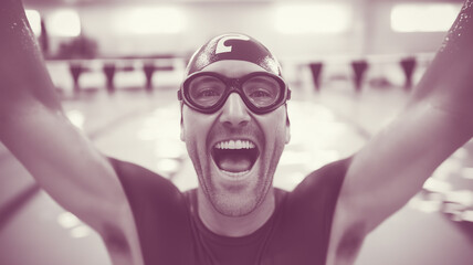 Fisheye portrait of a happy swim coach celebrating success in an indoor swimming pool, expressing joy and excitement