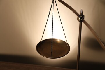 Scales of justice on beige background, closeup