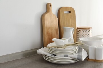 Different clean white dishware and cutting boards on counter in kitchen, closeup