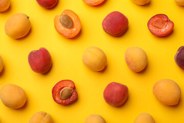 Many fresh apricots on yellow background, flat lay