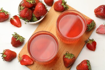 Tasty compot and strawberries on white table, flat lay