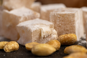 Turkish delight with peanuts close up, scattered oriental sweets Turkish delight with peanuts on a slate board