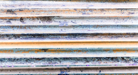 Abstract color-inverted image of rusty industrial pipes with high contrast tones in orange, blue and violet. Creative post-processing. Banner