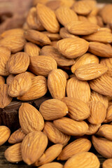 a lot of almonds on the table, ready-to-eat almond nuts on a wooden table, closeup