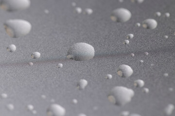 smooth silver colored metal surface covered with drops of pure water, wet silver-colored metal painted to protect aluminum alloy and metals, close up