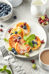 Cottage cheese pancakes with berries and condensed milk. Homemade dessert syrniki for healthy breakfast