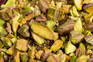 pistachios crushed into pieces of different sizes, a bunch of green crunchy pistachios, top view