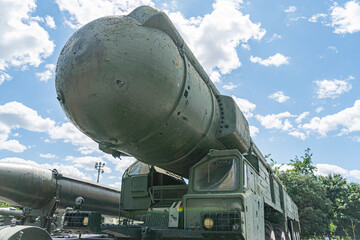 Large, olive green Ukrainian ballistic missile on a sturdy trailer with storage compartments Trailer equipped with large wheels and a robust suspension system Missile features multiple fins and a c