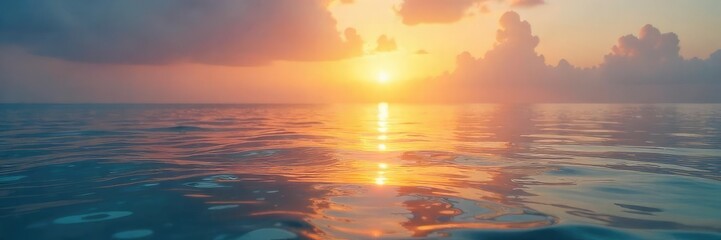 Obraz premium Serene sunrise over tranquil water, soft golden light illuminating calm waves and peaceful sky Perfect for relaxation themes, spa, wellness, nature, and travel imagery , yoga, sun