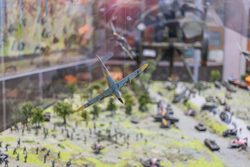 Detailed diorama of World War II battle scene, featuring soldiers, tanks, aircraft, and buildings Realistic earth tones with clear skies and greenery Showcases movement and action, suggesting comba