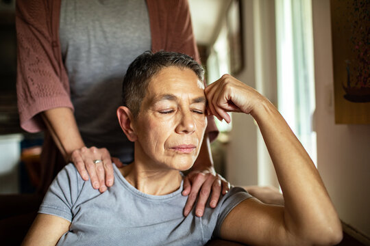 Stressed woman receiving comforting support from her lesbian partner at home