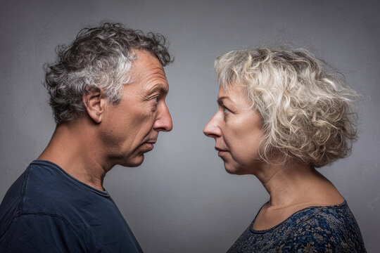 Candid moment captures the tension of a middle-aged couple during a family squabble in soft studio lighting