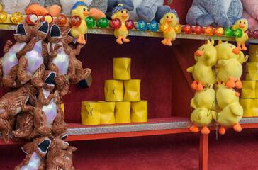fairground attraction stable with yellow cans and plush animals to be won