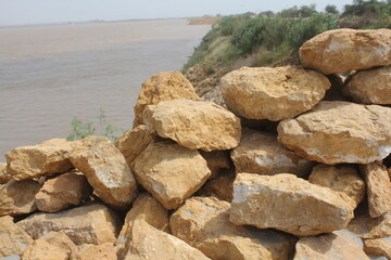 Stacked Rocks by a Riverbank under a Hazy Sky
