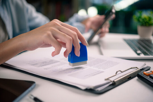 close-up of hand stamping a contract clipboard. contracts, and the final stages of a business agreement or legal process. official approval, and administrative efficiency.
