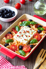 Baked feta cheese with farfalle pasta, basil, tomatoes and olives. Healthy food. Vegetarian food.