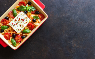 Baked feta cheese with farfalle pasta, basil, tomatoes and olives. Healthy food. Vegetarian food.