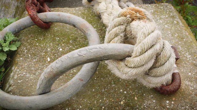 Boat mooring rope tied to round loop harbour wall stock footage