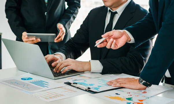 Employees and manager discuss financial plans using charts and IoT tech in an office meeting. teamwork marketing strategy and internet driven collaboration.