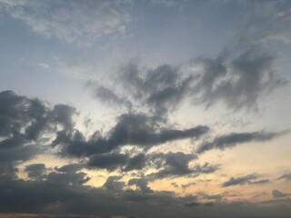 Dramatic sky at sunset with beautiful orange, blue, and grey clouds. A perfect natural background