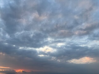 Dramatic sky at sunset with beautiful orange, blue, and grey clouds. A perfect natural background