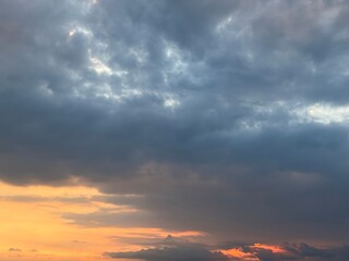 Dramatic sky at sunset with beautiful orange, blue, and grey clouds. A perfect natural background