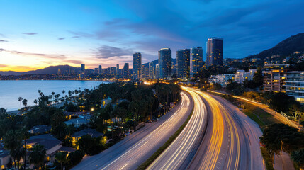 Obraz premium City skyline dusk with illuminated buildings and winding road. scene captures beauty of urban