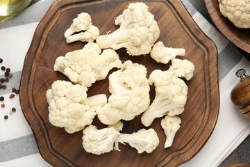 Fresh raw cauliflower florets and spices on table, flat lay