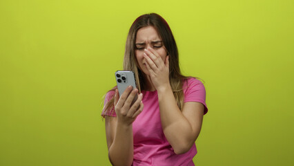 Woman in pink shirt reacting emotionally while holding phone against yellow background, showcasing a range of expressions.