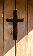 Wooden Door with Cross Cutout and Sunlight