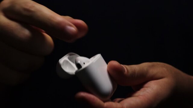 Man takes out earphones out of the case to listen to music