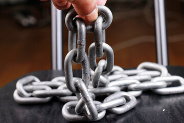 Naklejka premium Close-up of hand holding iron chain.