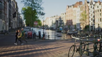 Fototapeta premium Blurred scene with man and woman strolling near amsterdam canals, showcasing defocused urban architecture and bicycles under clear sky, representing vibrant dutch city life.