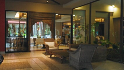 Blurred lobby scene with elegant wicker furniture in a luxury hotel setting, showcasing an inviting and peaceful atmosphere through its defocused and bokeh elements.