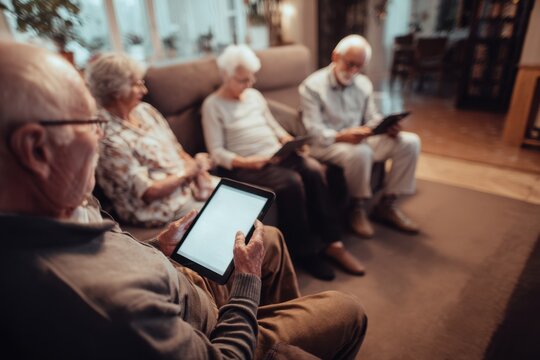 Seniors Engaging with Tablets in Cozy Living Room Setting.