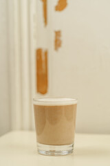 Beautiful Healthy Adaptogenic Drink in Glass, Trendy Vegan Elixir in Kraft Packaging on Rustic Table, Cozy Lifestyle Shot