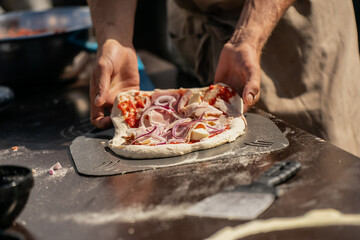 Hands preparing fresh dough with vegetables and toppings in rustic kitchen environment, showing authentic traditional cooking, homemade food preparation and lifestyle culinary experience