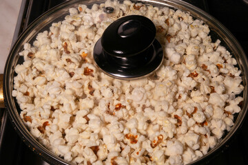 Popcorn popping in a covered saucepan on stovetop