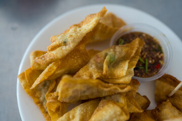 Delicious deep fried wonton wrapped pork with dipping sauce, appetizers