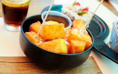 a bowl of spanish patatas bravas on a table
