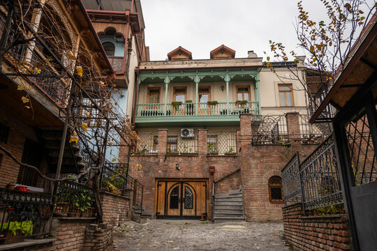 Rustic brickwork meets ornate wooden balconies. Reflects 19th-century architecture, a blend of European Asian styles. Typical for Old Tbilisi's historical districts.