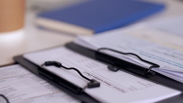 Patient medical records and observation charts on clipboards for healthcare data in a professional clinic office environment