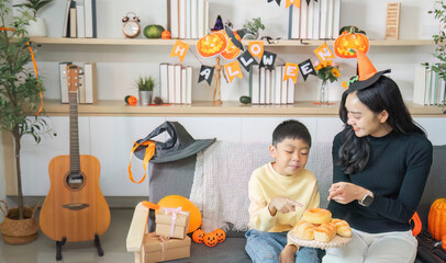 Halloween Treats. A mother and son enjoy festive snacks during Halloween celebrations.