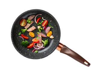 Close up of a frying pan with cooked meat and vegetables like tomatoes and broccoli on a black background