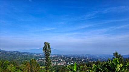 Fototapeta premium Mountains landscape. Panorama of beautiful countryside of Indonesia in sunny afternoon. landscape in mountains. grassy field and rolling hills. rural scenery with blue sky.