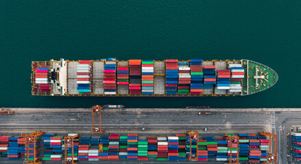 Obraz premium Aerial View of Cargo Ship Loaded with Colorful Containers at Port Terminal