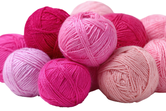 Collection of pink yarn balls arranged creatively with various shades in a soft light, ideal for crafting and knitting projects