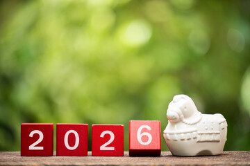2026 on the red logs and old white ceramic horse  on natural background.