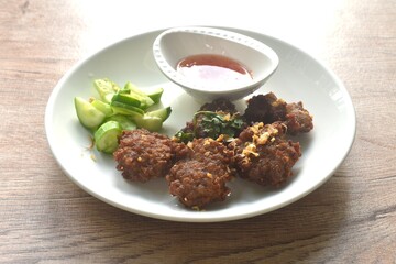 deep fried salty chop pork ball with garlic dipping sweet chili sauce and slice cucumber on plate
